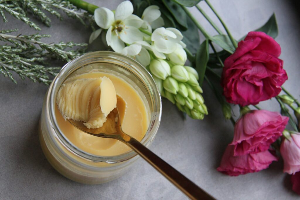 Ein Glas Ghee steht auf einem mit Blumen dekorierten Tisch