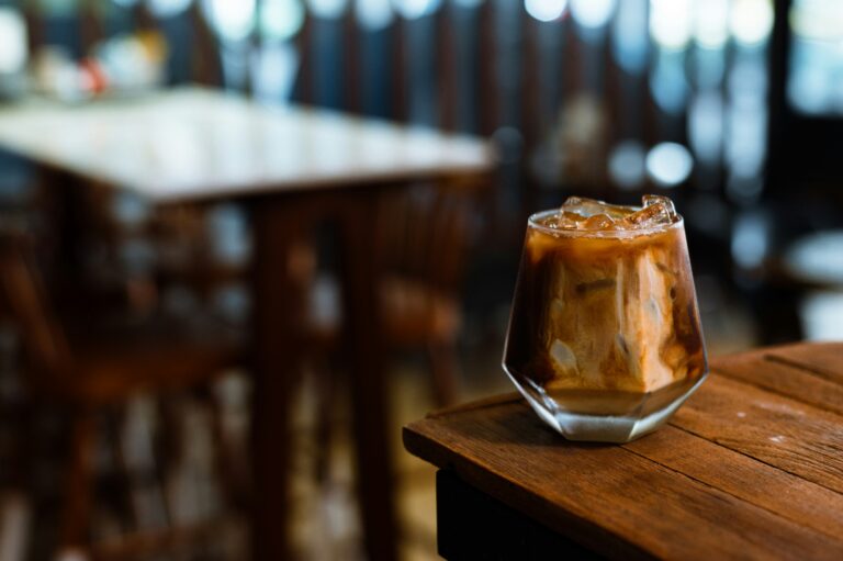Ein Eiskaffee steht auf dem Tisch in einem Café - verlockend, aber aus Sicht des Ayurveda sind eisgekühlte Getränke im Hochsommer bei Hitze keine gute Wahl